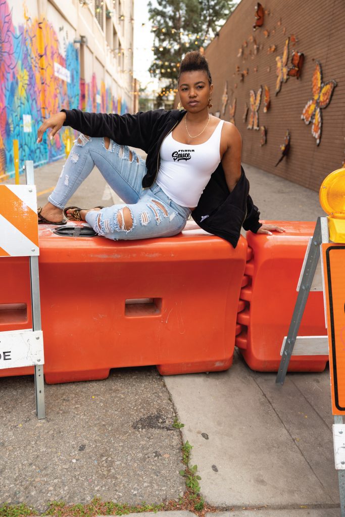 A woman sitting on top of orange barriers.