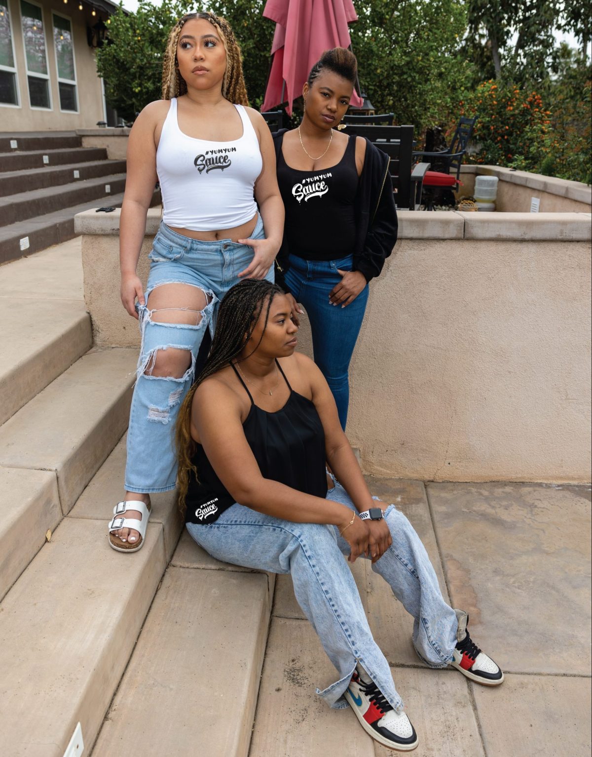 Three women sitting on steps posing for a picture.