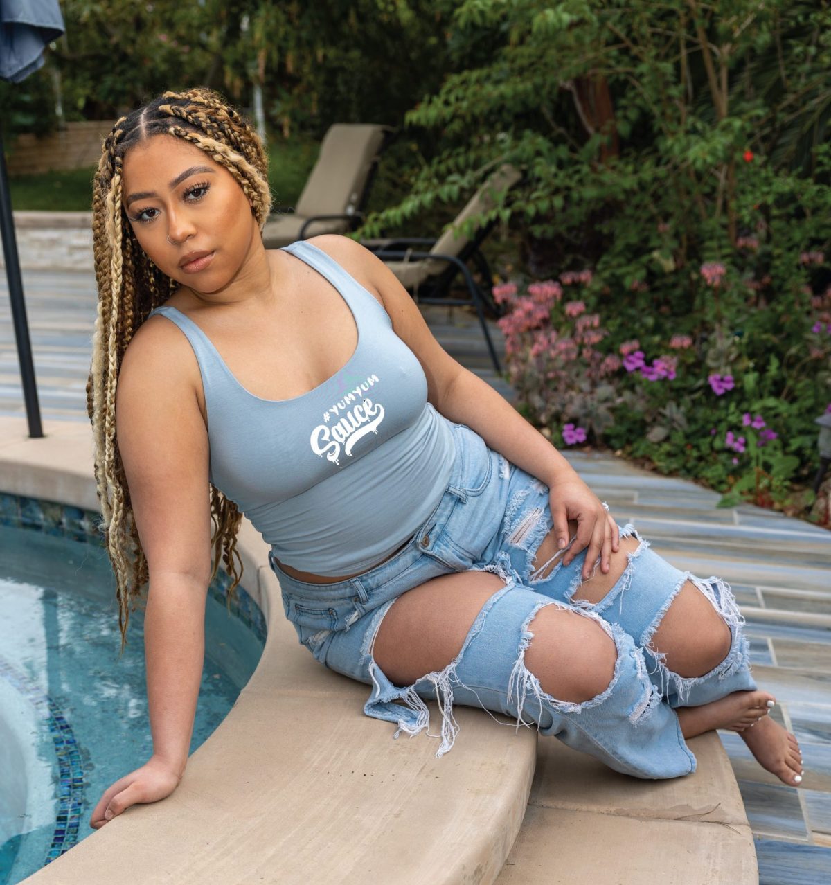 A woman sitting on the edge of a pool.